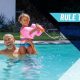 Man and little girl playing in a swimming pool. Rule The Pool in text