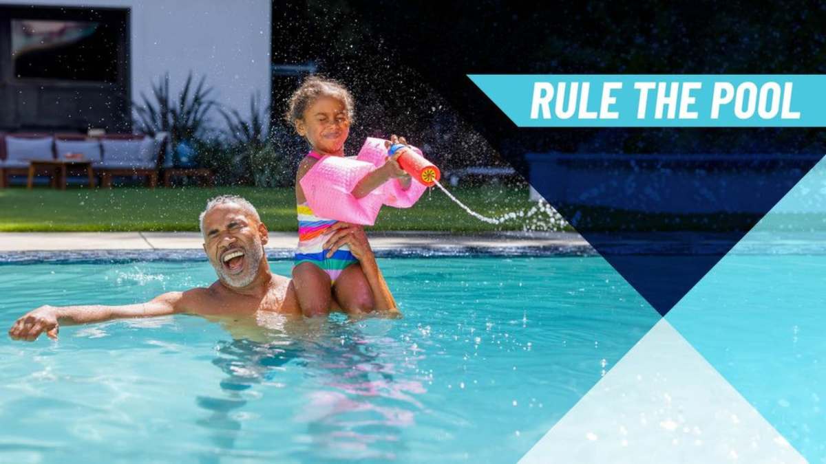 Man and little girl playing in a swimming pool. Rule The Pool in text