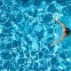 Woman swimming in a crystal clear blue pool