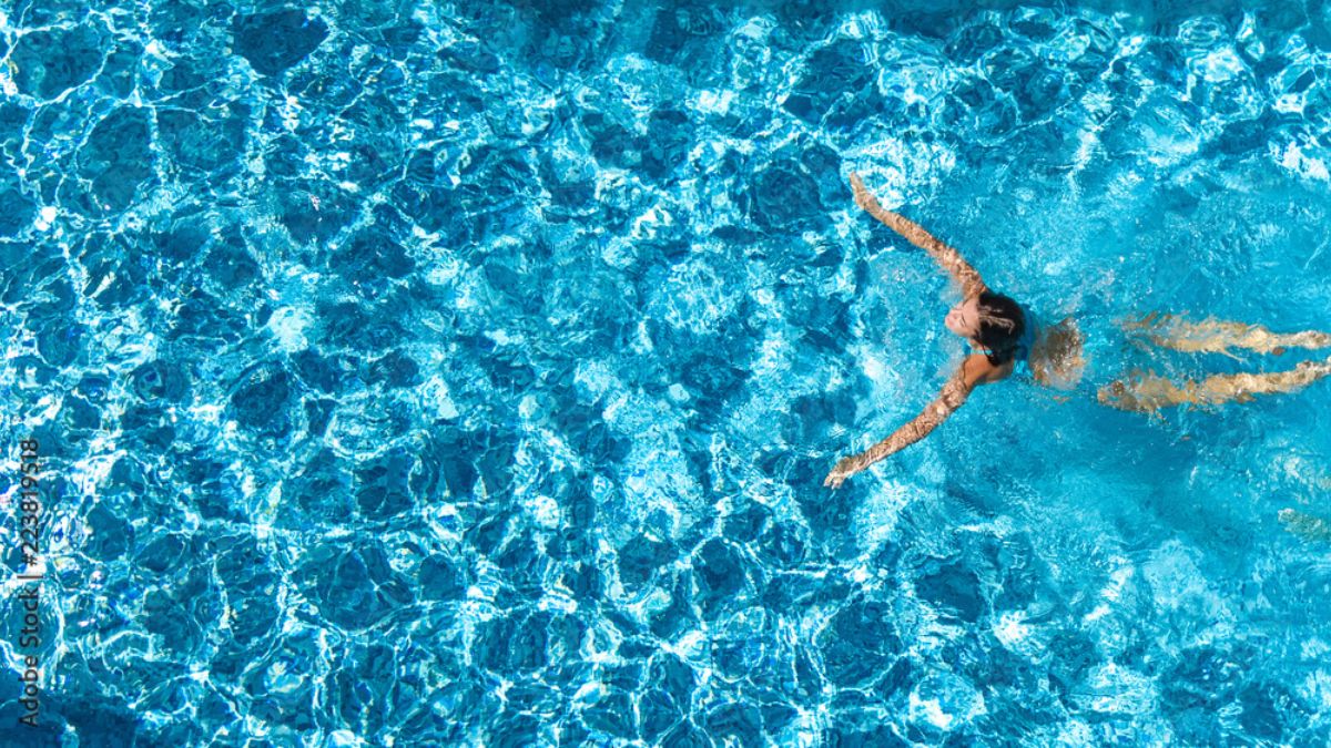 Woman swimming in a crystal clear blue pool