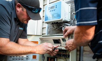 Two men fixing a Pentair IntelliCenter system.